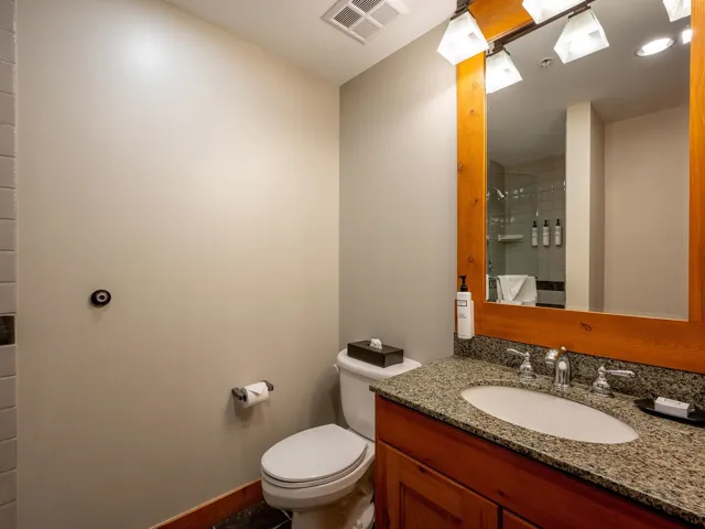 Full bath featuring tiled shower and vanity