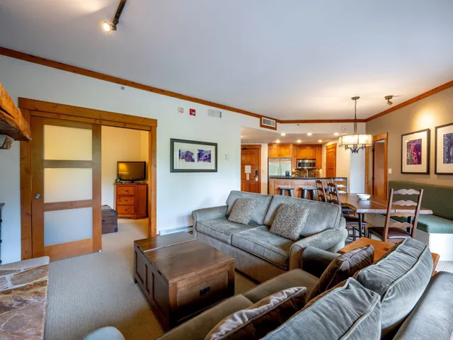 Living area featuring ornamental molding, a chandelier, and light colored carpet