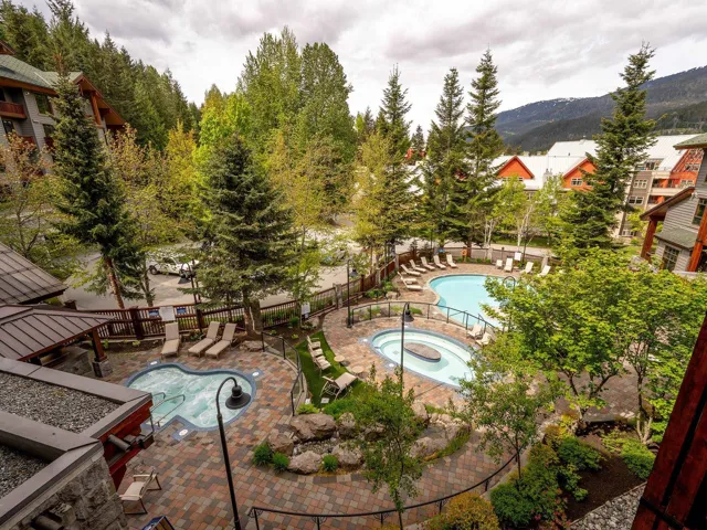 Community pool with a hot tub, a fenced backyard, a patio area, and a mountain view