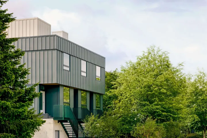Modern architectural exterior featuring vertical metal panel siding and multiple windows