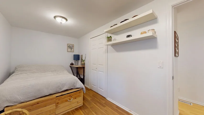 Bedroom featuring light wood-style flooring, baseboards, and visible vents