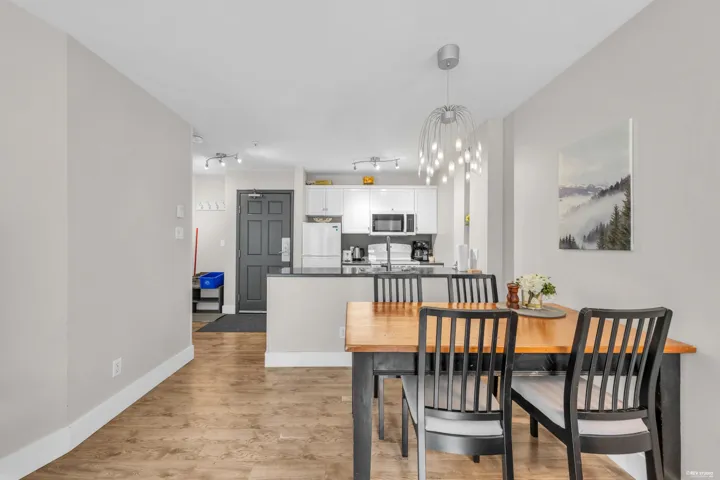 Dining area with wood-finish flooring and modern chandelier lighting
