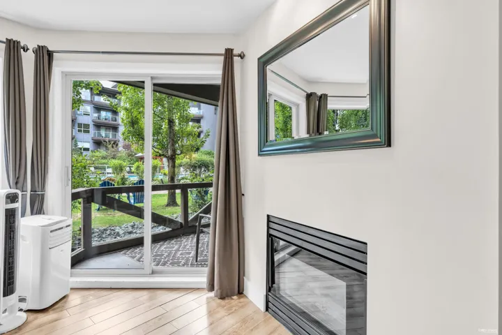 Sliding glass door opening to a private patio with wood-finish flooring