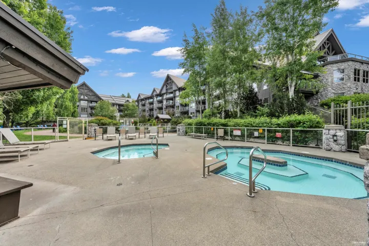 Outdoor aquatic area featuring two pools with integrated steps and stainless steel railings, surrounded by a concrete deck