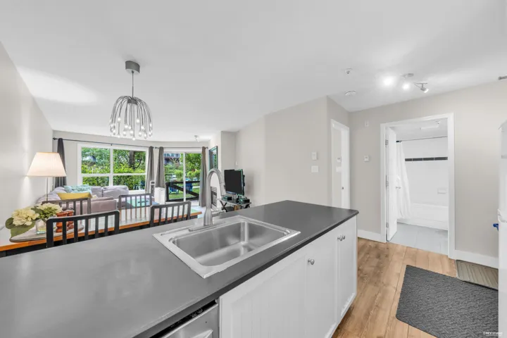 Kitchen island featuring a double-basin stainless steel sink and white cabinetry
