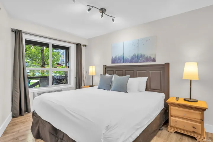 Spacious room featuring wood-finish flooring, a large multi-pane window, and track lighting