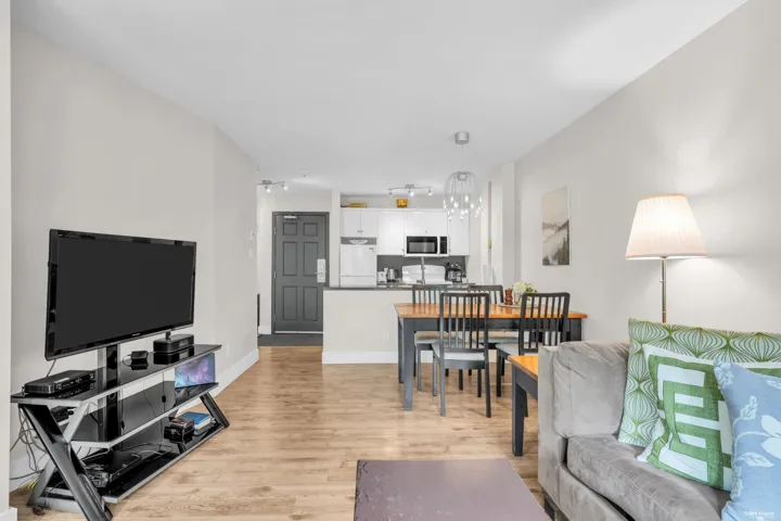 Open-concept living area featuring wood-finish flooring, white walls, and track lighting