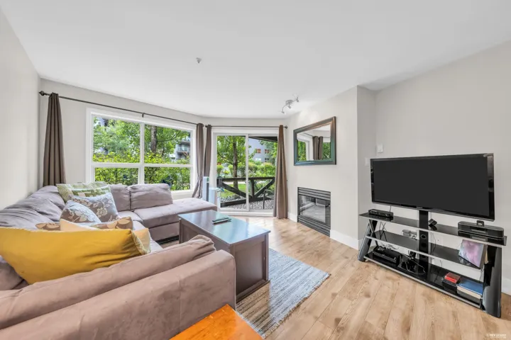 Living area featuring wood-finish flooring, a built-in fireplace, and a large window array with exterior views