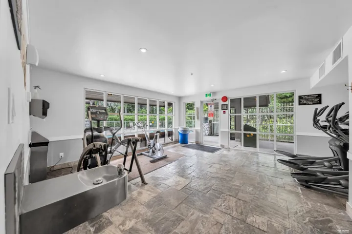 Recreational fitness room featuring a water fountain, recessed ceiling lighting, and expansive windows
