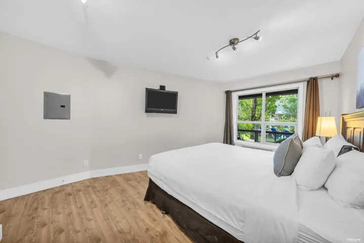 Light-filled room featuring wood-finish flooring and a large window with white trim