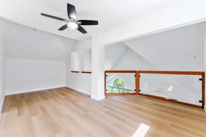 Additional living space with ceiling fan, vaulted ceiling, and light wood-type flooring