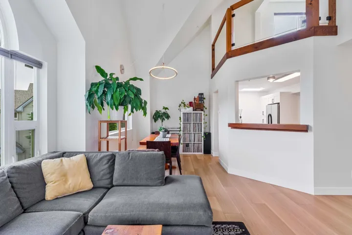 Living room featuring light wood-style flooring and a high ceiling