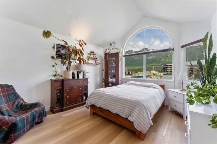 Bedroom featuring light wood-type flooring and lofted ceiling