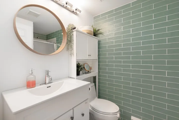 Bathroom featuring an enclosed shower, visible vents, toilet, and vanity