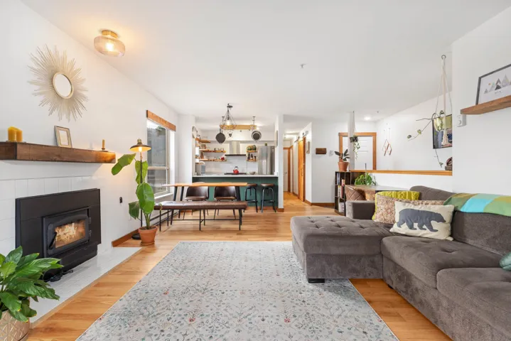 Living area with a tiled fireplace and light wood finished floors