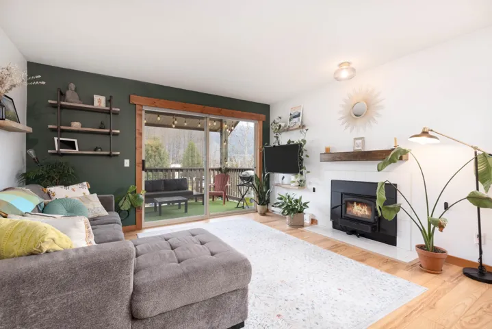 Living area featuring a tiled fireplace, wood finished floors, and baseboards