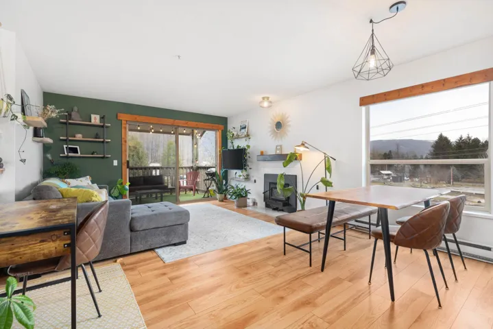 Dining room with a tiled fireplace and light wood-style flooring