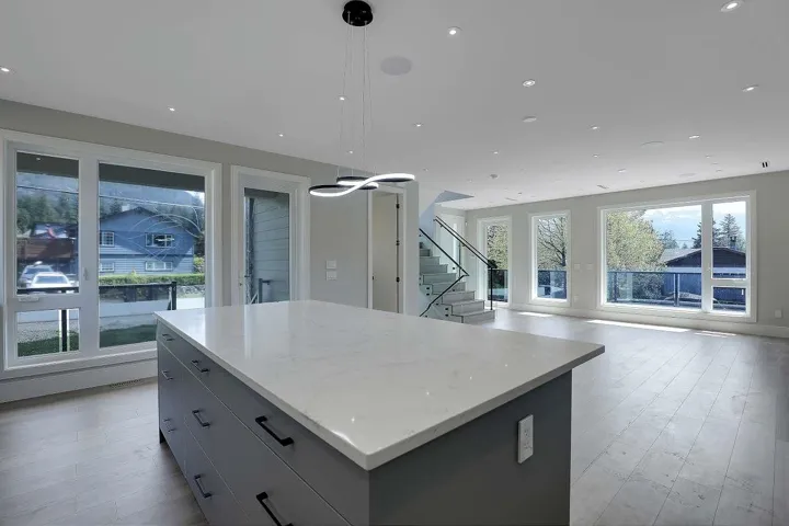 Kitchen with a kitchen island, open floor plan, recessed lighting, light stone countertops, and light wood-style flooring