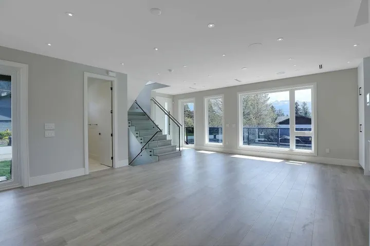 Unfurnished living room with baseboards, light wood-type flooring, stairs, and recessed lighting