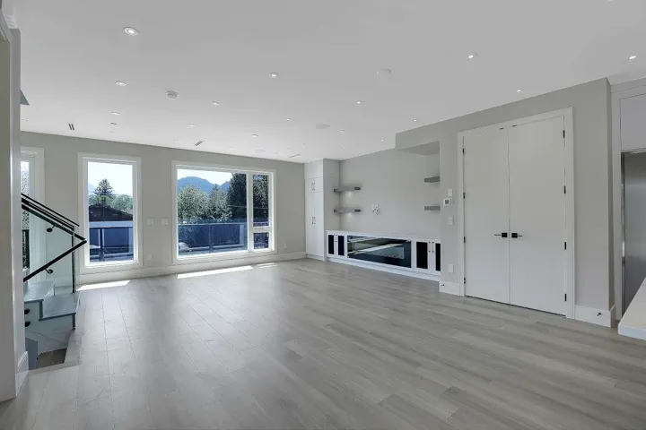 Unfurnished living room featuring light wood-type flooring, baseboards, stairway, and recessed lighting