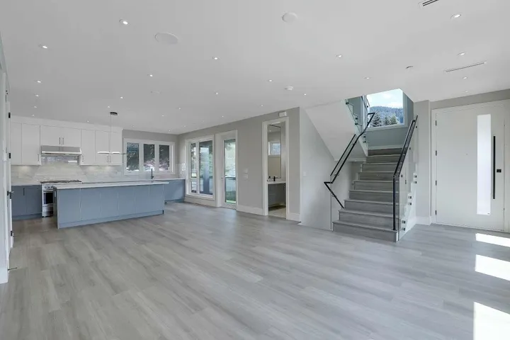 Unfurnished living room with light wood-style flooring, baseboards, stairs, and recessed lighting