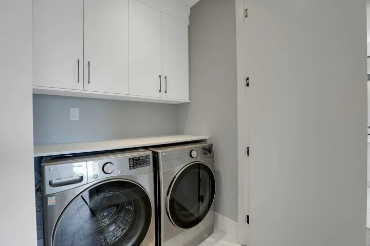 Washroom with washing machine and clothes dryer, cabinet space, and baseboards