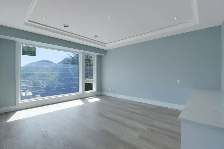 Spare room featuring a raised ceiling, light wood-style floors, baseboards, and recessed lighting