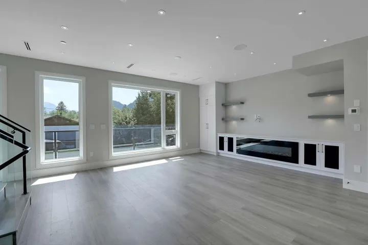 Unfurnished living room featuring wood finished floors, baseboards, and recessed lighting