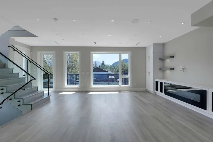 Unfurnished living room featuring baseboards, plenty of natural light, stairs, and recessed lighting