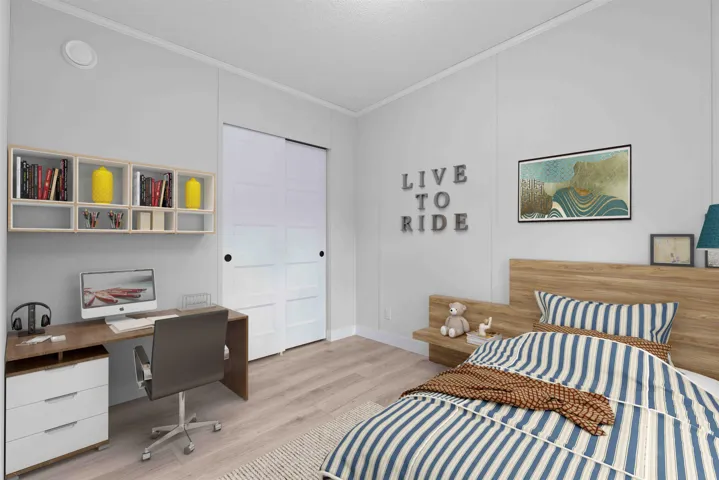 Bedroom with crown molding, with room for a desk, and a large closet. Photo has been virtually staged.