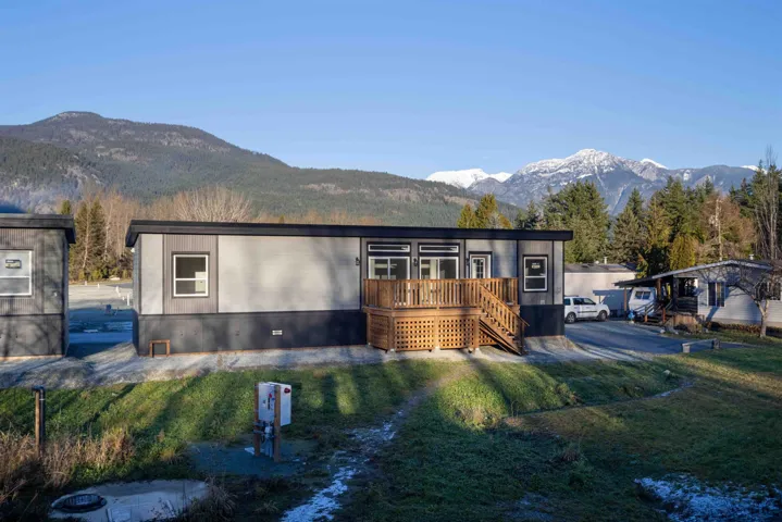 Single wide modular home featuring cement board siding and large wood deck and entry.