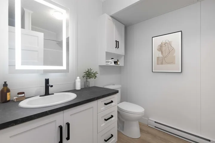 4pc Ensuite Bathroom featuring vanity, backlit mirror with tub / shower combination.  Photo has been virtually staged.