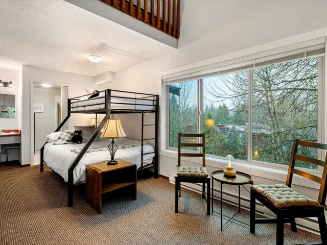 Carpeted bedroom featuring a textured ceiling and a baseboard radiator