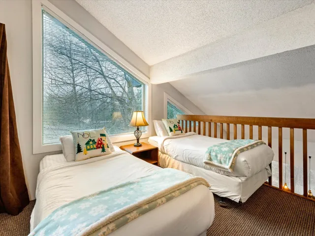 Carpeted bedroom with lofted ceiling and a textured ceiling