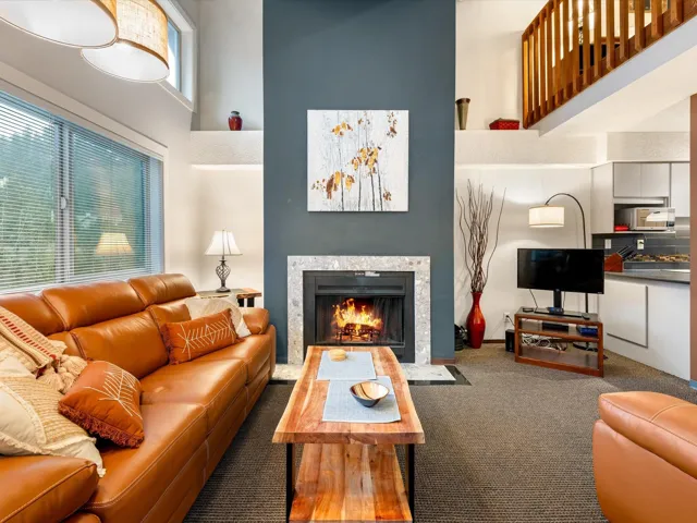 Carpeted living room with a high ceiling and a fireplace with flush hearth