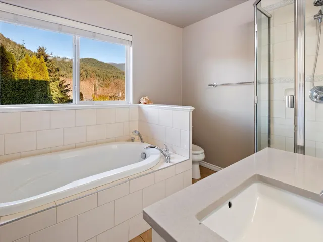 Full bath with a sink, a shower stall, toilet, and a bath