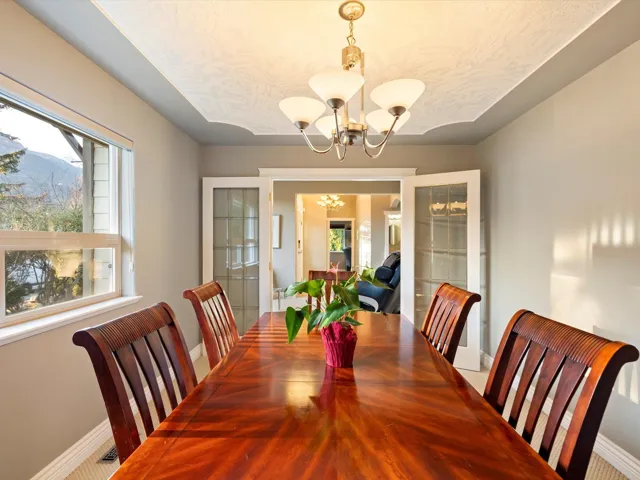 Dining space featuring baseboards, a chandelier, and a textured ceiling