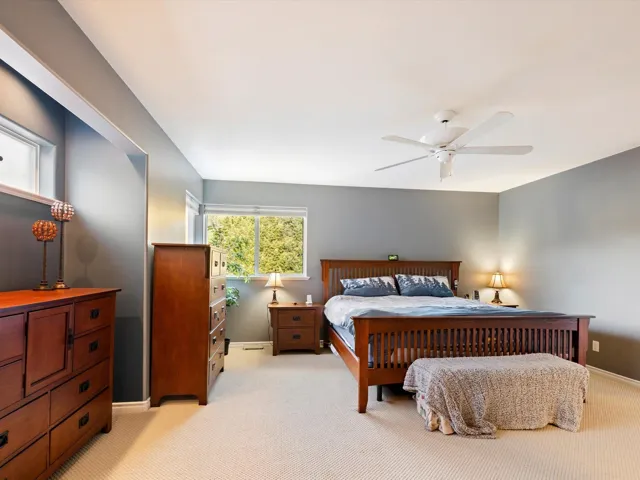 Bedroom with baseboards, a ceiling fan, and light colored carpet