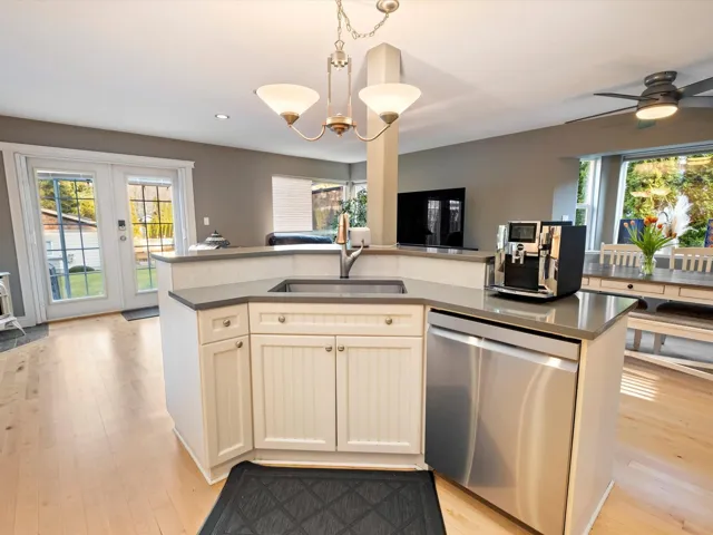 Kitchen featuring open floor plan, a sink, plenty of natural light, and stainless steel dishwasher