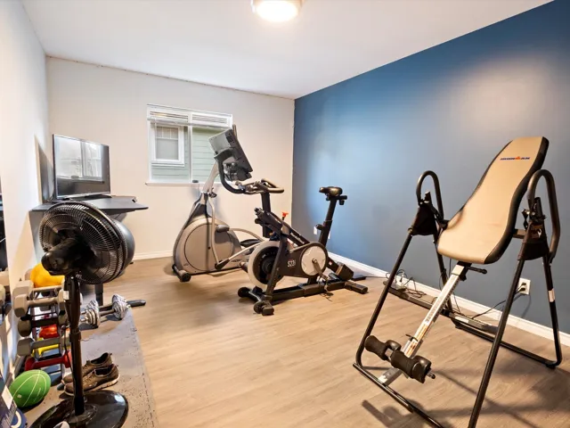 Exercise room featuring baseboards and wood finished floors