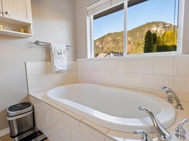 Bathroom featuring a garden tub and a mountain view