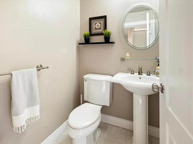 Bathroom featuring toilet, baseboards, a sink, and tile patterned floors