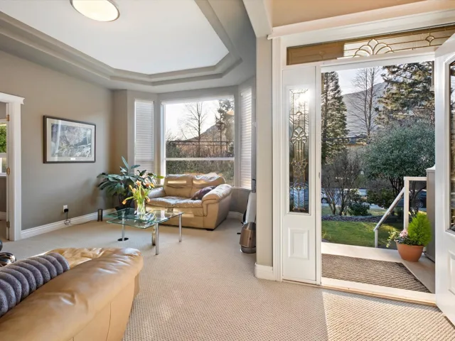 Interior space featuring baseboards, a tray ceiling, and light colored carpet
