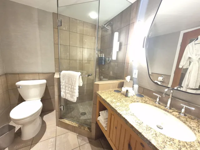 Bathroom featuring a stall shower, vanity, tile walls, and light tile patterned floors