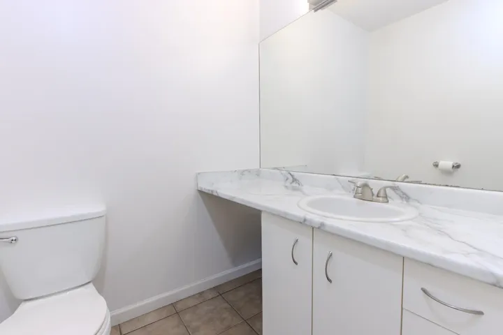Half bathroom with vanity and light tile patterned floors
