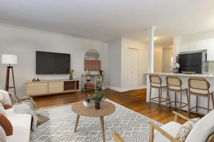 Living area featuring dark wood-style flooring and crown molding