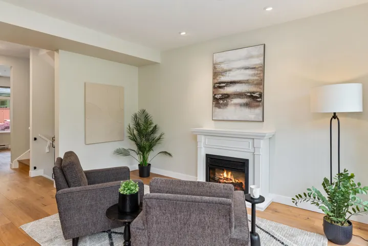 Living area featuring a glass covered fireplace, light wood-style flooring, baseboards, and recessed lighting