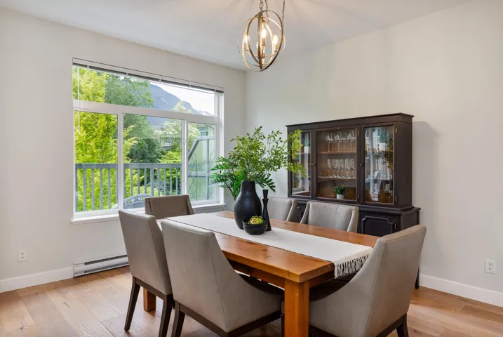 Dining space with baseboard heating, baseboards, a chandelier, and light wood finished floors