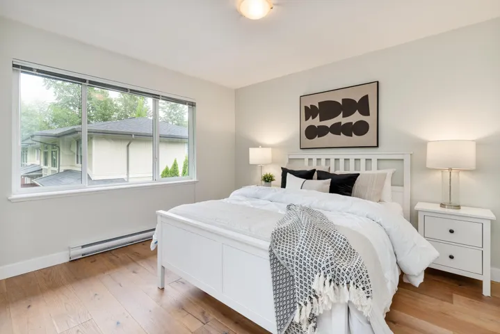 Bedroom featuring a baseboard heating unit, wood finished floors, and baseboards