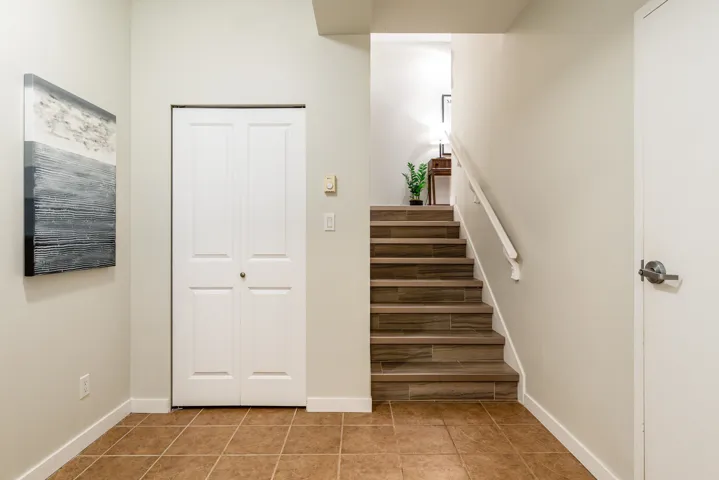 Staircase with tile patterned flooring and baseboards